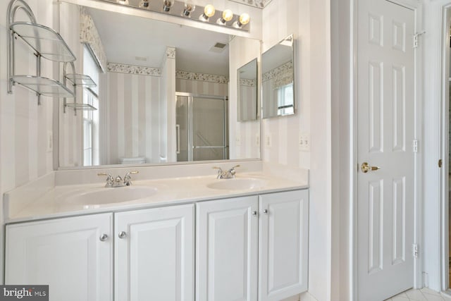 full bathroom featuring a stall shower, a sink, visible vents, and wallpapered walls