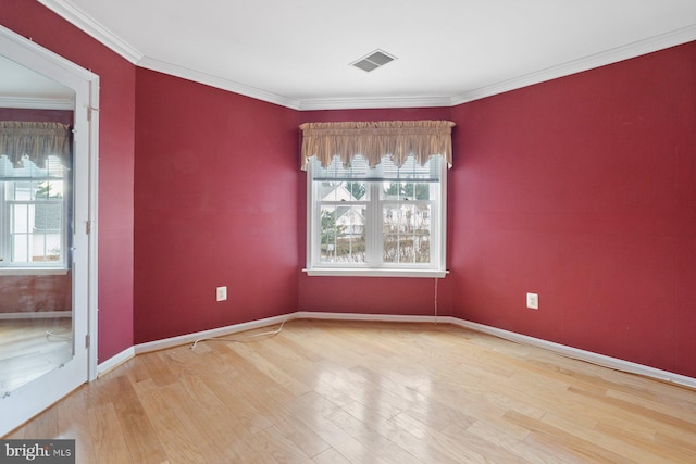 unfurnished room with ornamental molding, a wealth of natural light, and wood finished floors