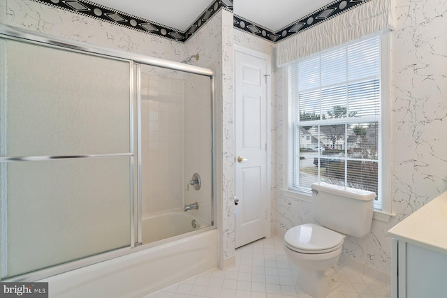 bathroom featuring wallpapered walls, toilet, shower / bath combination with glass door, tile patterned floors, and vanity