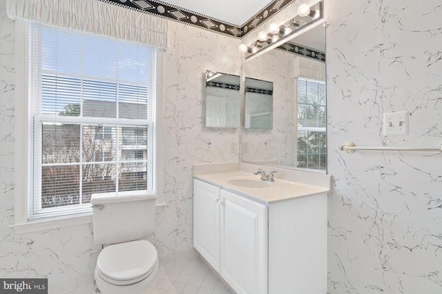 bathroom with toilet, tile patterned flooring, vanity, and wallpapered walls