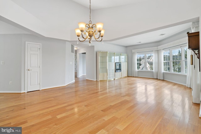 interior space featuring a notable chandelier, light wood-style flooring, and baseboards