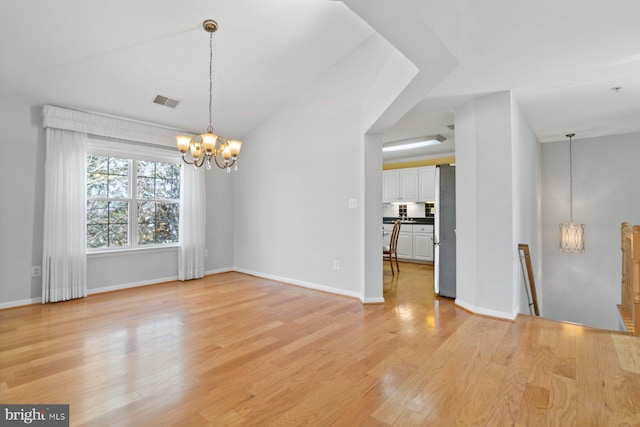 unfurnished dining area featuring baseboards, a notable chandelier, visible vents, and light wood finished floors