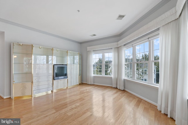 unfurnished living room featuring light wood finished floors, visible vents, ornamental molding, and baseboards