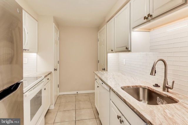 kitchen with white cabinetry, sink, backsplash, white appliances, and light tile patterned floors