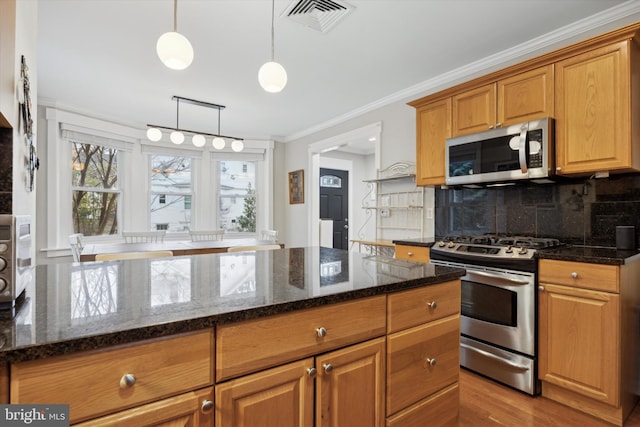 kitchen with dark stone countertops, decorative backsplash, hanging light fixtures, ornamental molding, and stainless steel appliances