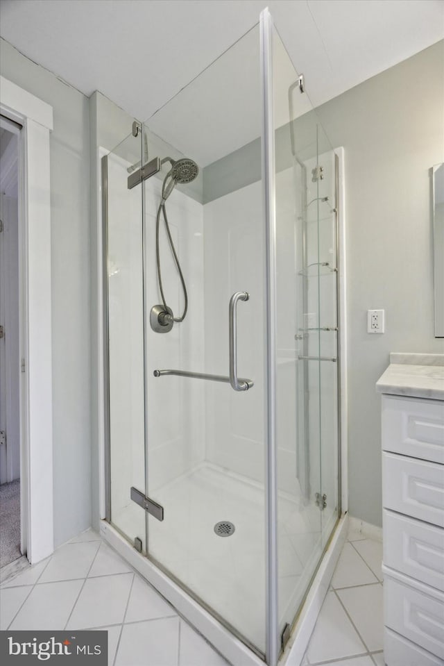 bathroom featuring vanity, tile patterned floors, and a shower with shower door