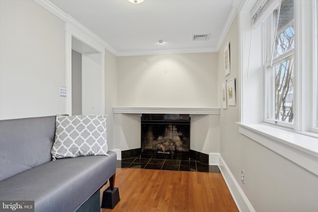 living room with a fireplace, ornamental molding, and dark hardwood / wood-style floors