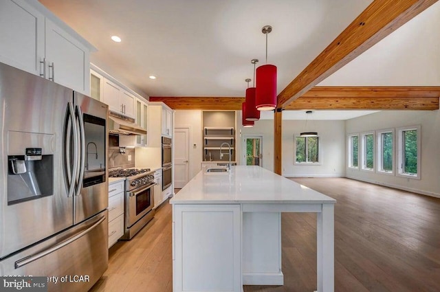 kitchen with sink, white cabinetry, pendant lighting, stainless steel appliances, and a kitchen island with sink