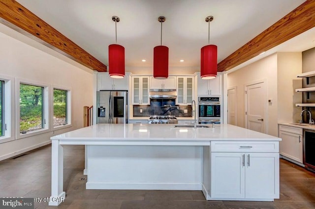 kitchen with appliances with stainless steel finishes, decorative light fixtures, sink, and white cabinets