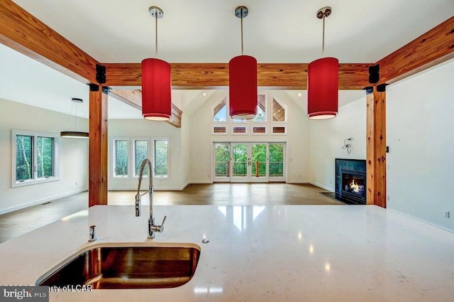 kitchen with lofted ceiling with beams, decorative light fixtures, and sink