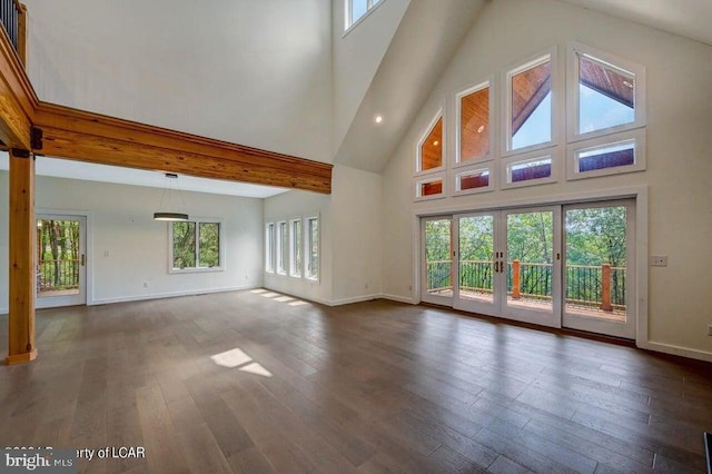 unfurnished living room with french doors, dark hardwood / wood-style floors, and a high ceiling