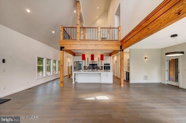 unfurnished living room with dark hardwood / wood-style flooring and a high ceiling