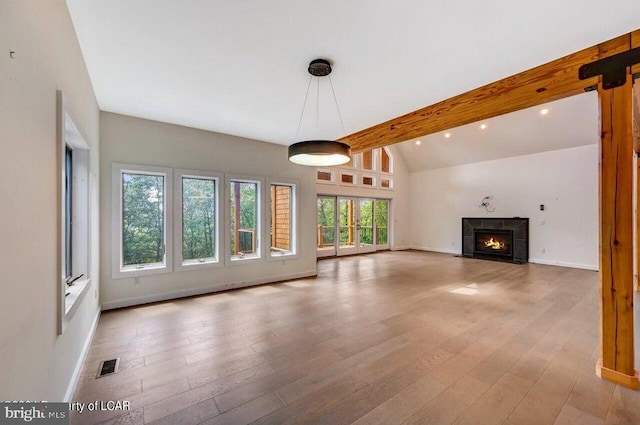 unfurnished living room featuring light hardwood / wood-style floors and vaulted ceiling with beams