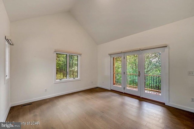 empty room featuring high vaulted ceiling and dark hardwood / wood-style floors