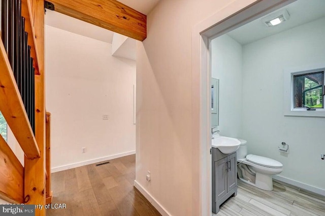 bathroom featuring vanity, wood-type flooring, and toilet