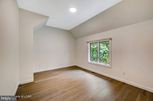 bonus room featuring wood-type flooring and vaulted ceiling