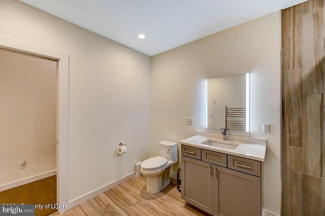 bathroom featuring vanity, hardwood / wood-style floors, and toilet