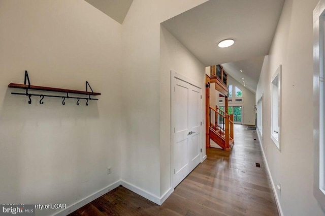 corridor featuring lofted ceiling and hardwood / wood-style flooring