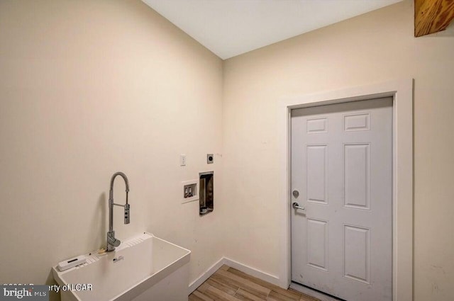 clothes washing area with hookup for a washing machine, sink, hookup for an electric dryer, and light hardwood / wood-style flooring