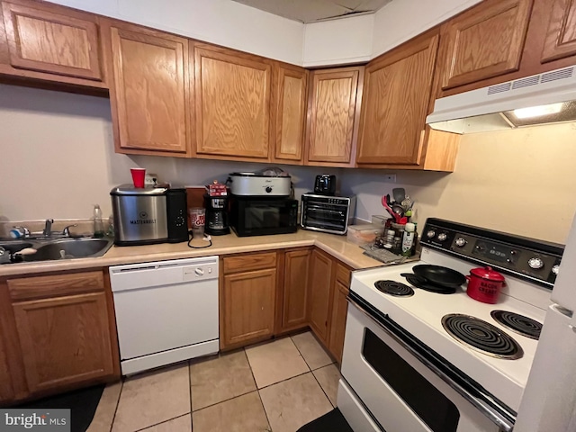 kitchen featuring sink, white appliances, and light tile patterned floors