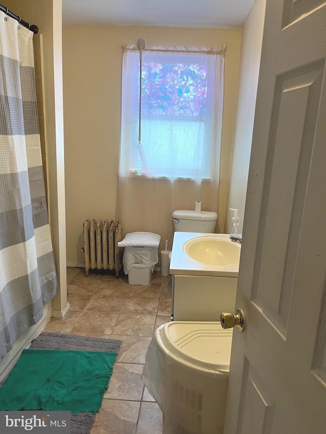 bathroom featuring vanity, radiator, and curtained shower