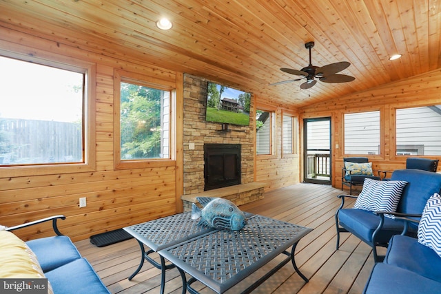 living room with vaulted ceiling, wooden walls, an outdoor stone fireplace, light hardwood / wood-style floors, and wooden ceiling