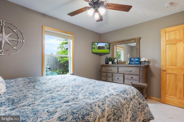 carpeted bedroom featuring ceiling fan and multiple windows