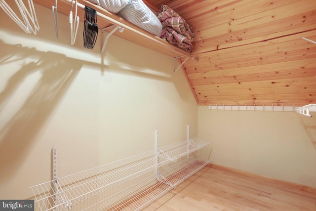 walk in closet featuring wood-type flooring and vaulted ceiling