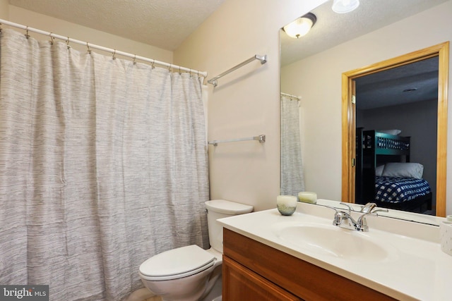 bathroom featuring vanity, a textured ceiling, and toilet