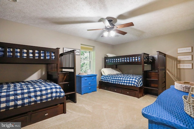 bedroom featuring ceiling fan, light colored carpet, and a textured ceiling