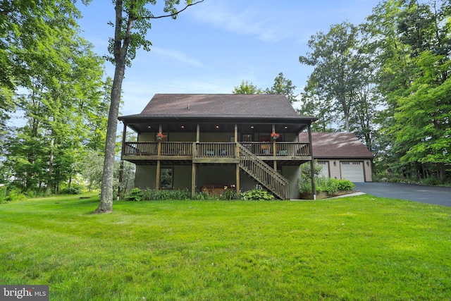 view of front of property featuring a garage, a wooden deck, and a front lawn