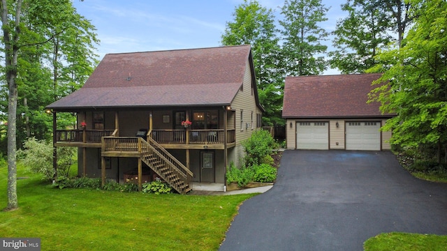 view of front of home with a garage, a deck, and a front lawn