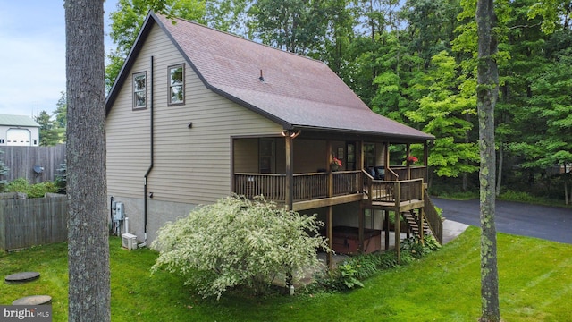 back of house with a yard, a hot tub, and a deck