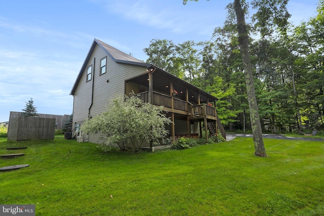 back of property featuring a wooden deck and a yard