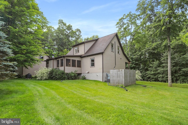 back of house with a sunroom and a lawn