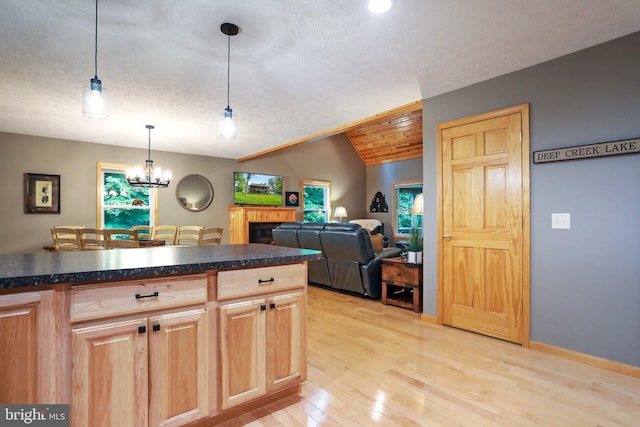 kitchen featuring plenty of natural light, decorative light fixtures, light hardwood / wood-style floors, and vaulted ceiling