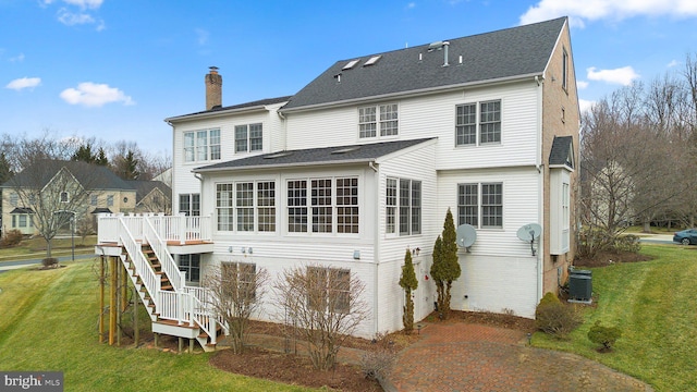 rear view of property featuring a wooden deck, a yard, and central AC unit