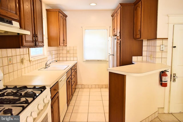 kitchen with light tile patterned flooring, white appliances, sink, and backsplash