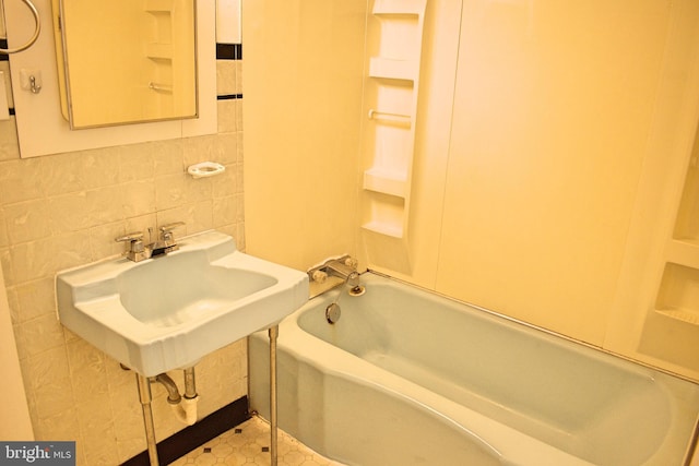 bathroom with tile walls, sink, and decorative backsplash