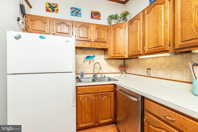 kitchen featuring tasteful backsplash, white fridge, sink, and stainless steel dishwasher