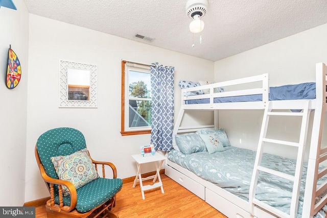 bedroom with hardwood / wood-style floors and a textured ceiling