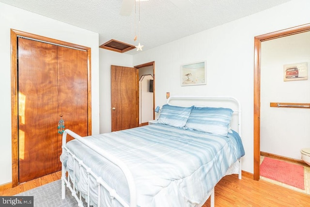 bedroom featuring hardwood / wood-style floors, a closet, a textured ceiling, and ceiling fan