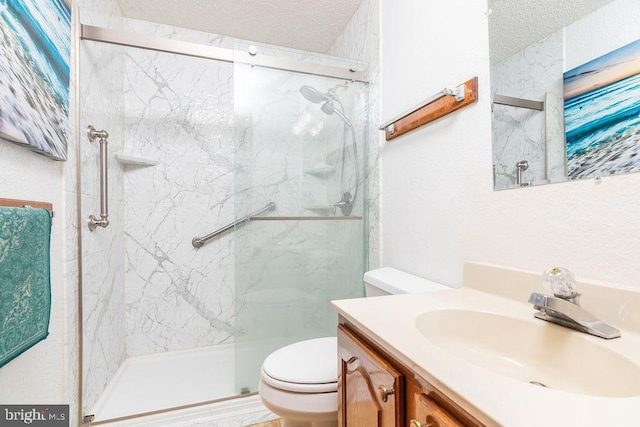 bathroom with vanity, a textured ceiling, a shower with door, and toilet