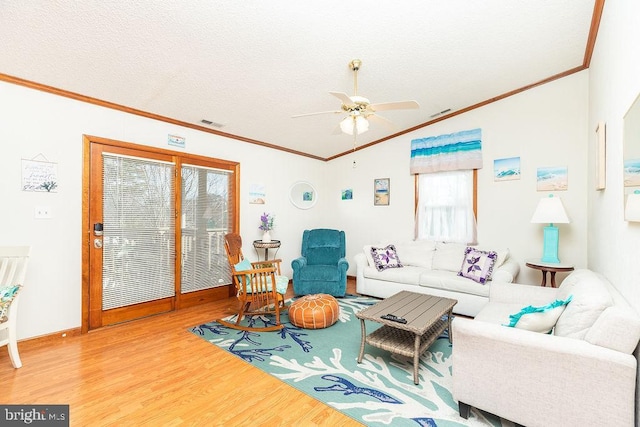 living room featuring hardwood / wood-style flooring, ornamental molding, ceiling fan, and a textured ceiling