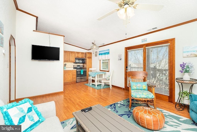 living room with lofted ceiling, light hardwood / wood-style flooring, ornamental molding, and ceiling fan