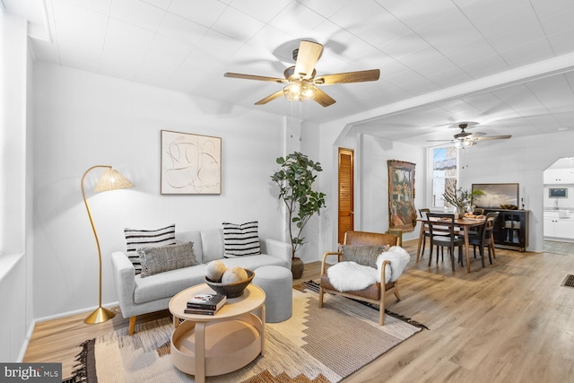 living room with ceiling fan and light hardwood / wood-style flooring