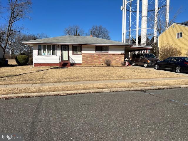 view of front of property with a front yard and a carport