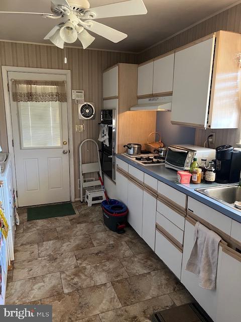 kitchen with crown molding, multiple ovens, white gas cooktop, and white cabinets