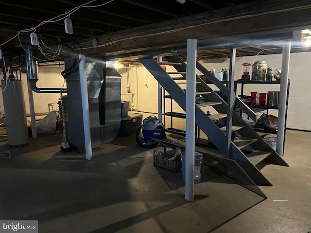 basement featuring heating unit and water heater