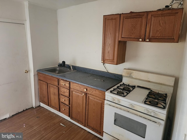 kitchen with white gas range, sink, and dark hardwood / wood-style flooring